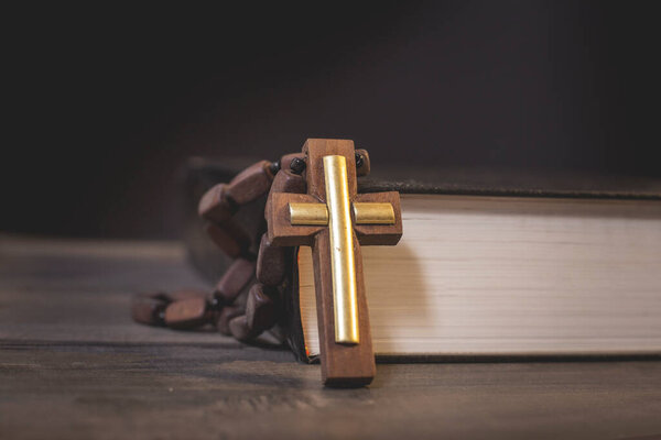 Book and cross on a wooden table