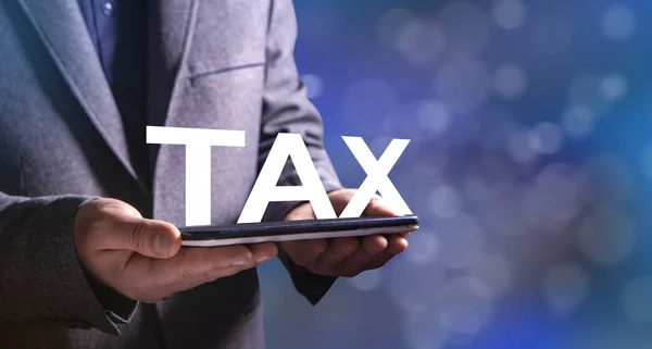 Mężczyzna Trzyma Tabliczkę Ręku Napis Tax — Zdjęcie stockowe