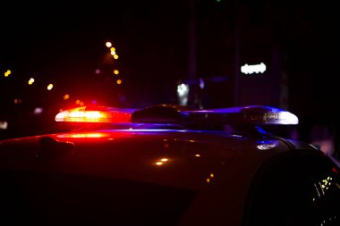 Polis arabası gece kentinde duruyor.