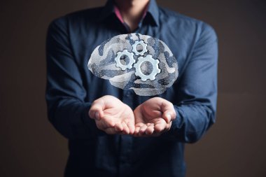 Şebekeden beyin ve dişliler. Elinde tutan adam.