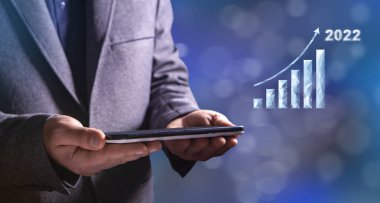Büyüme grafiği 2022. Elinde tablet tutan bir adam.