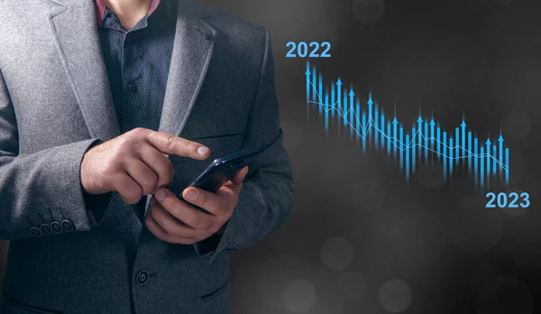 2022年から2023年への成長率低下 男は電話画面をタップ ロイヤリティフリーのストック画像