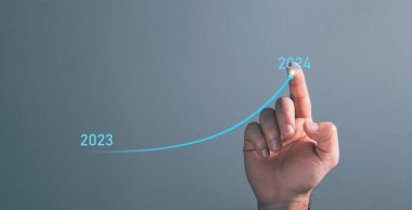 Ok 2023 'ten 2024' e kadar yükseliyor. Bir adam ekrana tıklıyor.