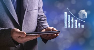 Falling graph on the property from the network. Man holding a tablet in his hand