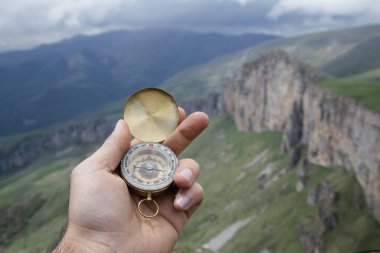 Dağın tepesindeki adamın elinde pusula. Dağın tepesinde pusula.