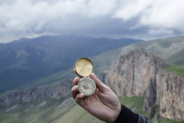 Dağın tepesindeki adamın elinde pusula. Dağın tepesinde pusula.