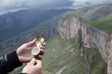 Dağın tepesindeki adamın elinde pusula. Dağın tepesinde pusula.