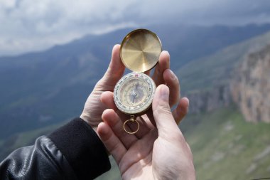Dağın tepesindeki adamın elinde pusula. Dağın tepesinde pusula.