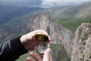 Dağın tepesindeki adamın elinde pusula. Dağın tepesinde pusula.