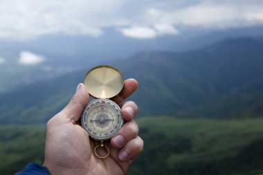 Dağın tepesindeki adamın elinde pusula. Dağın tepesinde pusula.