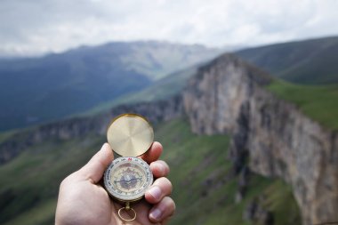 Dağın tepesindeki adamın elinde pusula. Dağın tepesinde pusula.