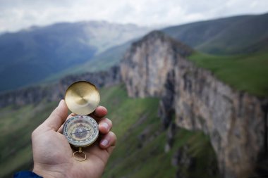 Dağın tepesindeki adamın elinde pusula. Dağın tepesinde pusula.