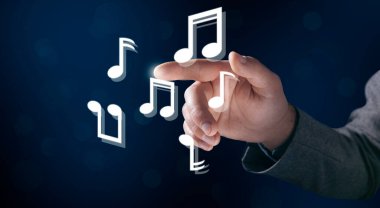 Adam müzikal nota sembolleri üzerinde sanal ekrana tıklıyor