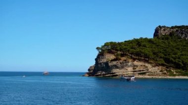 Ada boyunca yat, yat parkı, mavi göl, dağ manzarası, yeşil dağlar, mavi su, tekneler ve yatlar, eğlence yatı.