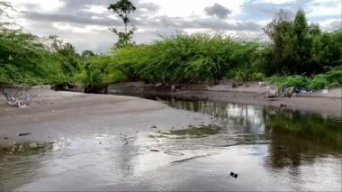 Filipinler Dağlardan akan nehir, plastik ve diğer çöp ekolojileriyle birlikte kirliliğin kıyılarından denize akar. Yüksek kalite 4k görüntü