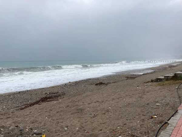 Çalkantılı deniz kum kıyısını çakıl taşlarıyla karıştırır. Yüksek kalite fotoğraf