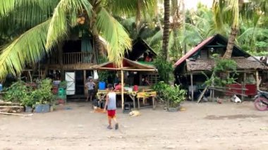 Geleneksel fakir balıkçı kulübesi bambu ve palmiye yapraklarından yapılmıştır. Balıkçılar akşam balığa gitmek için beklerler, çocuklar etrafta koşarlar. Yüksek kalite 4k görüntü