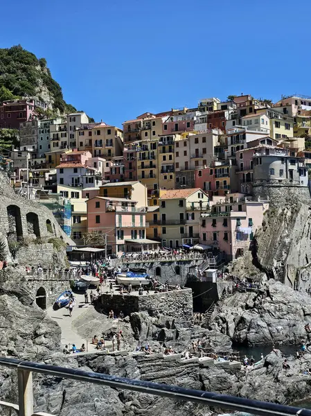 Manarola 'da turist hayatı, Cinque Terre. Ünlü köyün sokaklarında tanınmayan insanlar. Dikey fotoğraf.