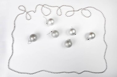 Gümüş zincir, gümüş noel toplarıyla birlikte bir Noel çerçevesi olarak düzenlenmiş. Fotoğrafın ortasında uzayı kopyala.