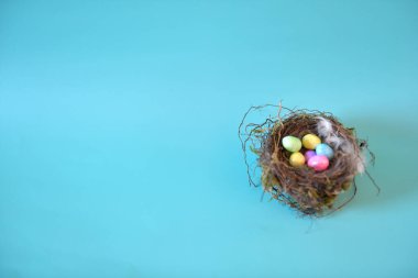 Turkuaz arka planda renkli Paskalya yumurtalarının yatay fotoğrafı. Uzayı sola kopyala.