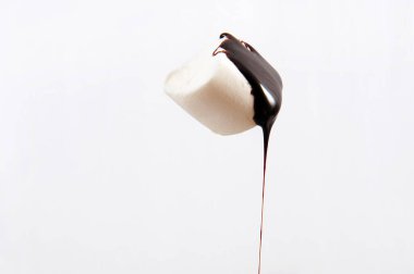 One single marshmallow with chocolate sauce running floating in the air against white background. Horizontal photo with copy space. clipart