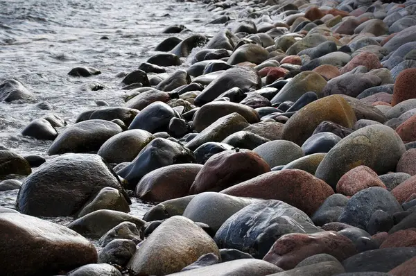 stock image Vertical photo of wet, dark and colorful boulders. 