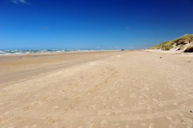 Blue sky and sandy beach in Loekken, Denmark. Horizontal photo. clipart