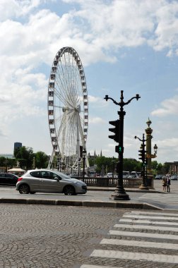 Paris 'teki sokak sahnesinin dikey fotoğrafı. Arka planda dönme dolap var. Yaya geçidi..