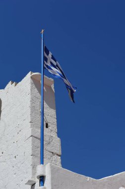 Yunanistan 'ın Rodos kentindeki açık mavi gökyüzüne karşı beyaz kuleden dalgalanan Yunan bayrağı. Kopyalama alanı olan dikey fotoğraf.