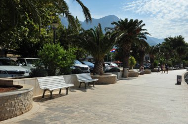 Baska Voda 'nın sahil yolu. Uzaktaki insanlar ve cadde boyunca park etmiş arabalar..