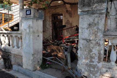 Karadağ 'ın Petrovac kentinde terk edilmiş bir bina. Ön bahçe hurdayla kaplı..