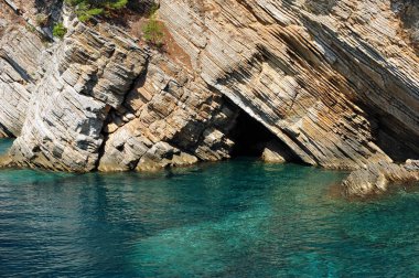 Karadağ 'ın Petrovac kentindeki beyaz kayalıkların ve turkuaz mavi kristal berrak okyanus suyunun yakın fotoğrafını çek. Kopyalama alanı olan yatay resim.