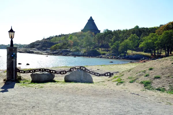 stock image Memorial pyramid in Stavern, Vestfold, Norway. Sand beach and boulders with solid chain in front of horizontal photo.  