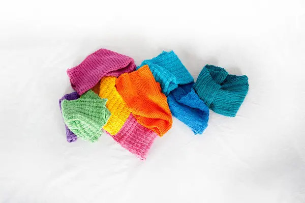 stock image Colorful dishcloths centered in the middle of horizontal photo. Copy space on white surface surrounding knitted kitchen cloths.