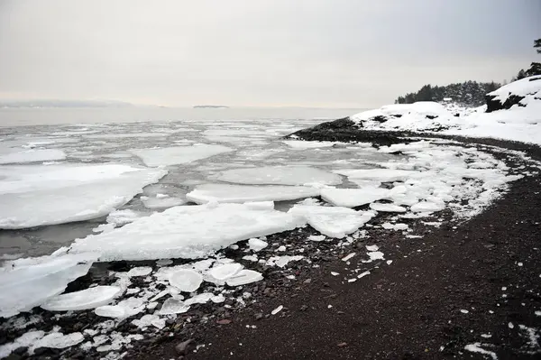 stock image Coastal winter scene from Horten, Norway.  Loevoeya, Mamre Lund in Vestfold.  Ice and snow along the beach. Horizontal photo shot on cloudy day.