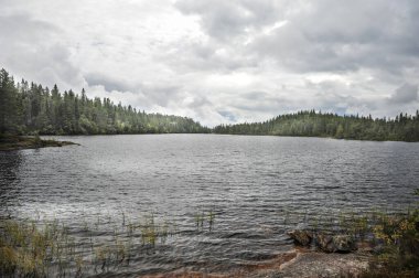 Vestfold, Skrim 'deki Skrimsvannet gölünde bulutlu bir gün. Norveç. Göldeki dalgalar ve bulutlu hava.