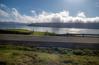 Faroe Adaları, Kirkjuboeur 'daki eski Faroe ev binaları güneşli bir günde. Taş çitler, tepeler ve açık mavi gökyüzü. Fotoğrafın alt kısmında boşluk kopyala.