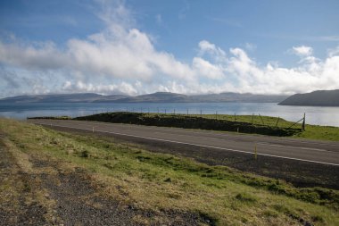 Faroe Adaları, Kirkjuboeur 'daki eski Faroe ev binaları güneşli bir günde. Taş çitler, tepeler ve açık mavi gökyüzü. Fotoğrafın alt kısmında boşluk kopyala.