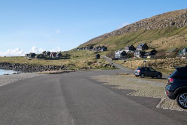 Faroe Adaları, Kirkjuboeur 'daki eski Faroe ev binaları güneşli bir günde. Taş çitler, tepeler ve açık mavi gökyüzü. Fotoğrafın alt kısmında boşluk kopyala.