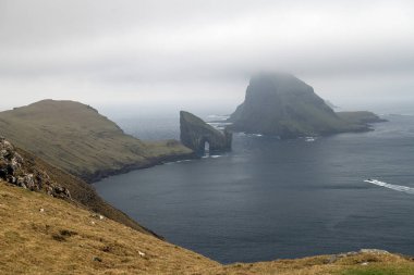 Drangarnir yürüyüş parkurundan uzakta görüldü. Faroe Adaları, Danimarka kalın sisli bir bahar günü.