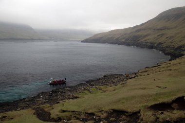 Turistler Drangarnir 'i açık teknede bırakıyorlar. Tanınan kimse yok. Bulutlu bir günde Faroe deniz manzarası.