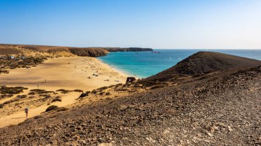 Playa Mujeres, Playa Blanca, Yaiza, Lanzarote, Las Palmas, Islas Canarias, İspanya ve Avrupa 'dan manzara. Atlantik Okyanusu 'nun berrak turkuaz sularıyla yıkanmış altın kum..