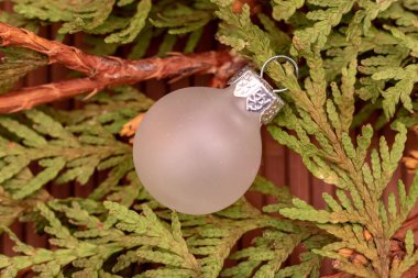 white christmas tree ball on green branches. Close up, top view, flat lay.
