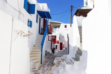 Yunanistan 'ın Mykonos şehrinde merdivenleri, renkli kapıları ve pencereleri olan beyaz tenli bir sokak. Geleneksel Kiklad mimarisi. Yüksek kalite fotoğraf