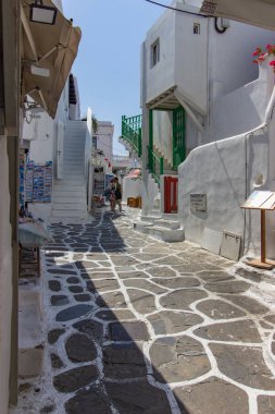 Yunanistan 'ın Mykonos şehrinde merdivenleri, renkli kapıları ve pencereleri olan beyaz tenli bir sokak. Geleneksel Kiklad mimarisi. Yüksek kalite fotoğraf