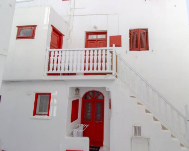 Yunanistan 'ın Mykonos şehrinde merdivenleri, renkli kapıları ve pencereleri olan beyaz tenli bir sokak. Geleneksel Kiklad mimarisi. Yüksek kalite fotoğraf