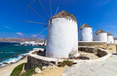 Mikonos adasında bulutlu gökyüzünün altında geleneksel Yunan yel değirmenleri. Yunanistan 'ın Cyclades kentindeki ikonik Mykonos yel değirmenlerinin hava görüntüsü. Seyahat ve mimari konsepti. Yüksek kalite fotoğraf