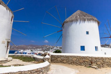 Mikonos adasında bulutlu gökyüzünün altında geleneksel Yunan yel değirmenleri. Yunanistan 'ın Cyclades kentindeki ikonik Mykonos yel değirmenlerinin hava görüntüsü. Seyahat ve mimari konsepti. Yüksek kalite fotoğraf