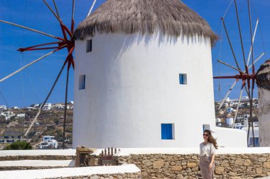 Mikonos adasında bulutlu gökyüzünün altında geleneksel Yunan yel değirmenleri. Yunanistan 'ın Cyclades kentindeki ikonik Mykonos yel değirmenlerinin hava görüntüsü. Seyahat ve mimari konsepti. Yüksek kalite fotoğraf