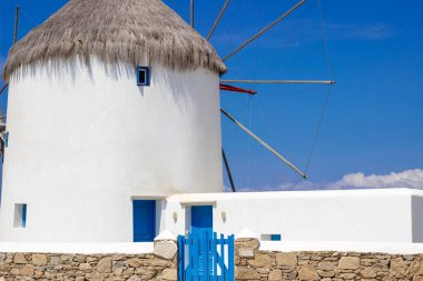 Traditional Greek windmills on Mykonos island under cloudy sky. Aerial view of iconic Mykonos windmills in Cyclades, Greece. Travel and architecture concept. High quality photo clipart